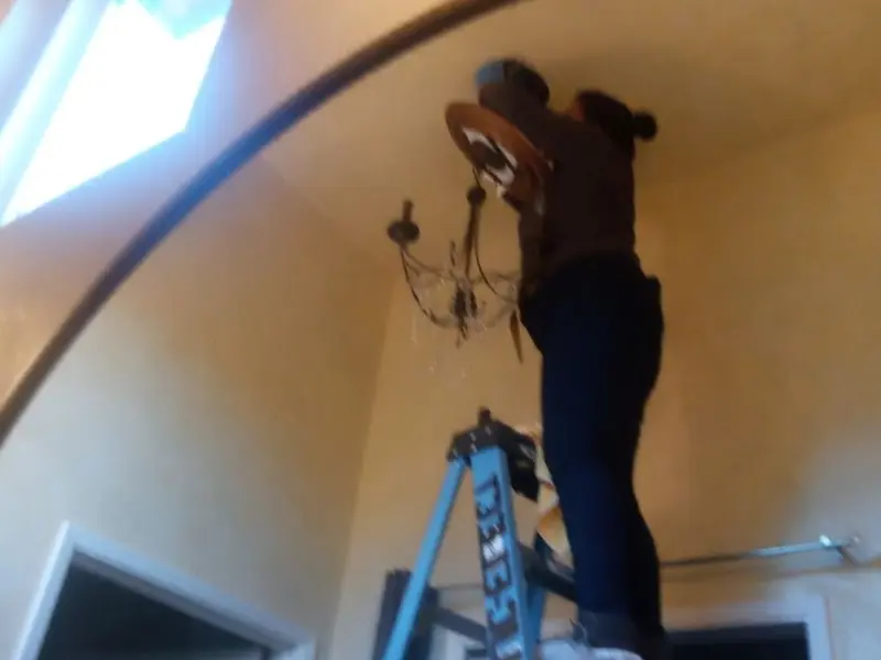 Electrician installing a chandelier in a Boulder Creek residence